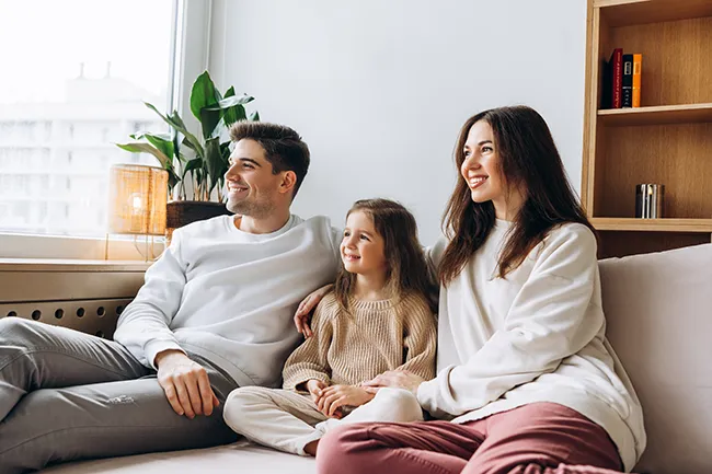 a family sitting in their new home's living room